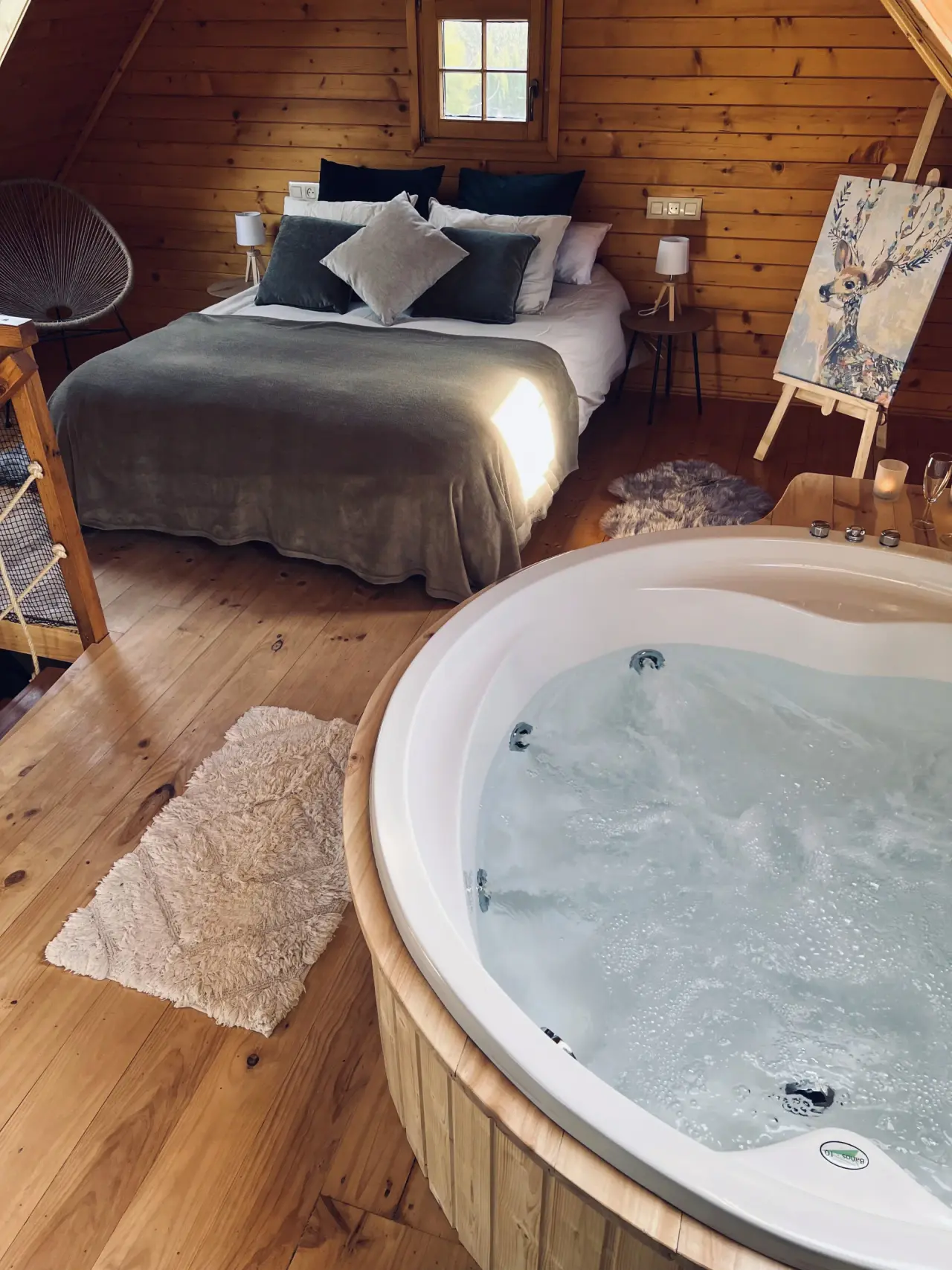 Jacuzzi redondo de hidromasaje con agua burbujeante en primer plano, dentro de una habitación con paredes y suelo