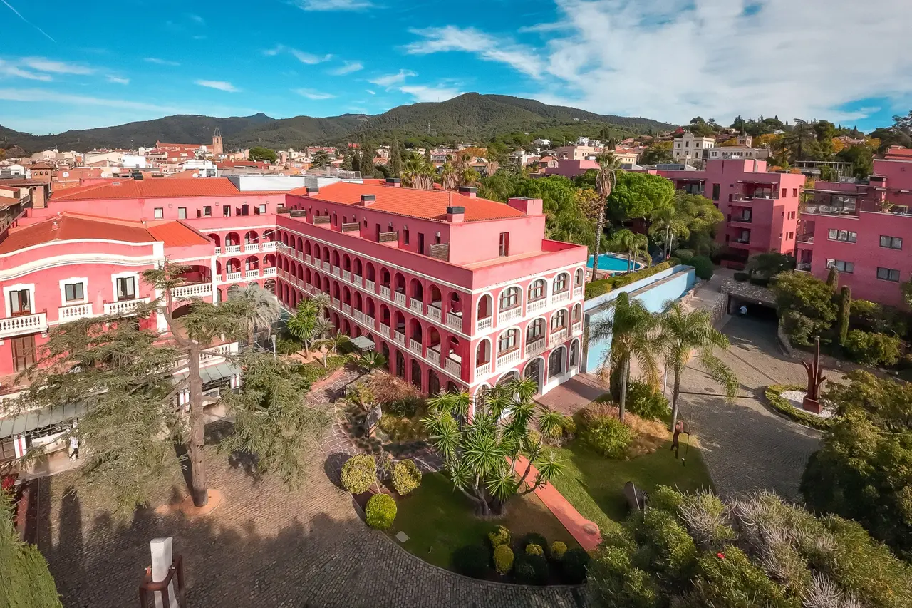 Vista aérea del Hotel Blancafort Spa Termal, con sus edificios de color rosa y tejados rojos rodeados de jardines