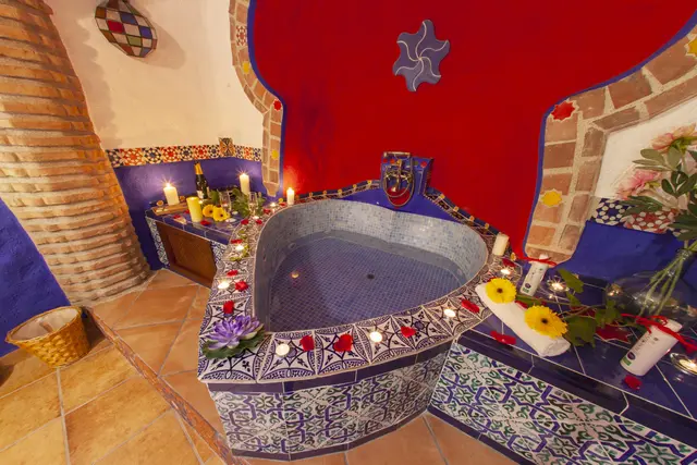 Casas Cueva Cazorla: Jacuzzi en forma de corazón con azulejos azules y blancos, situado en una habitación con paredes rojas y azules, rodeado