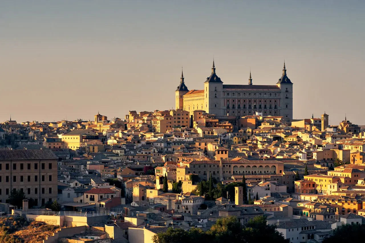 Vista panorámica de Toledo al atardecer con el Alcázar dominando la ciudad histórica.