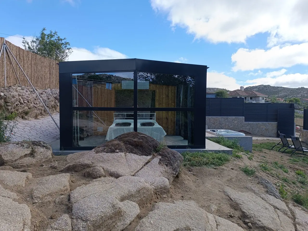 Cabina de vidrio con cama interior y bañera de hidromasaje exterior climatizada en parcela privada rodeada