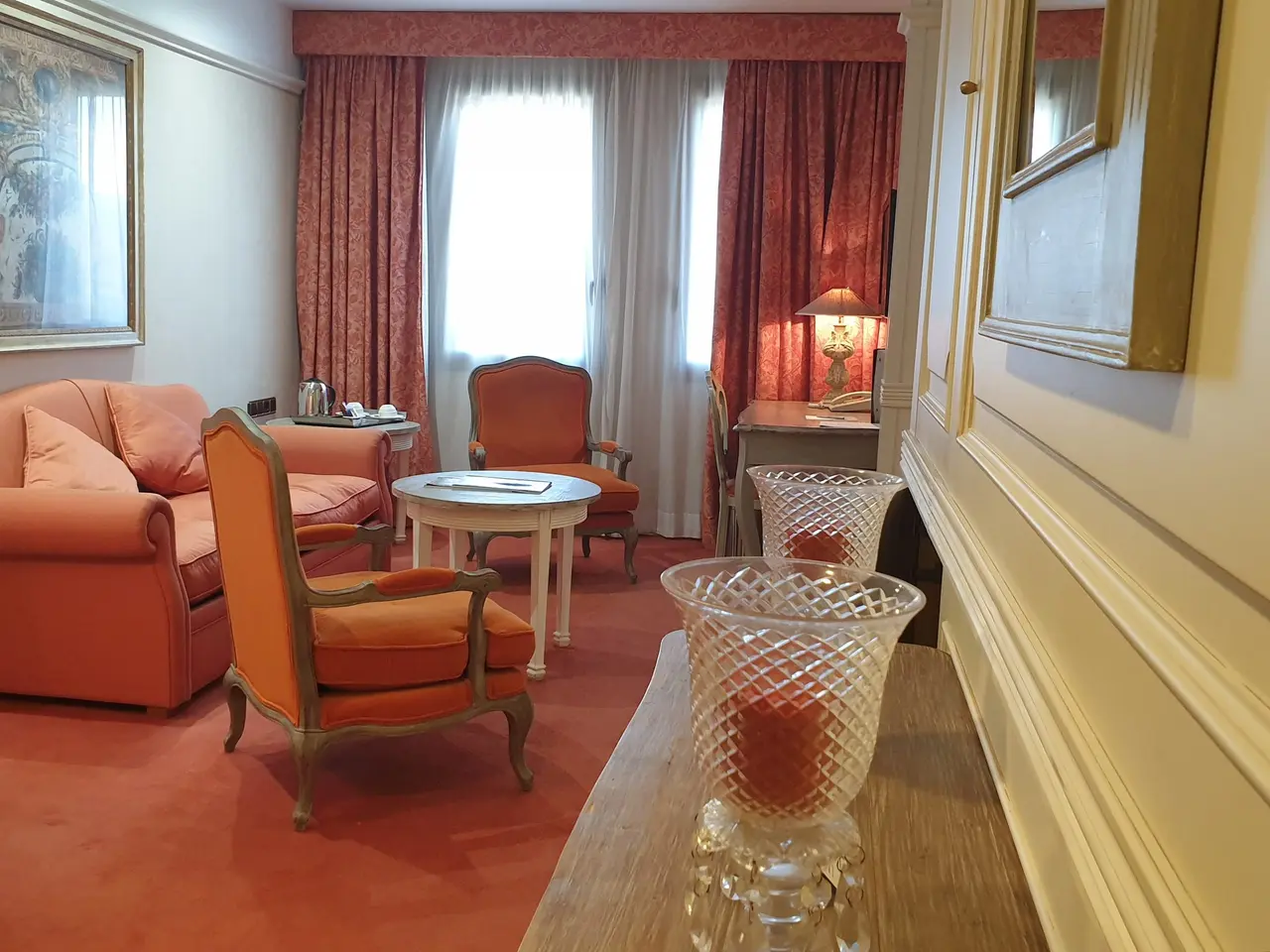 Vista de una sala de estar en una suite ejecutiva junior, con sofá y sillones de color salmón, mesa de centro