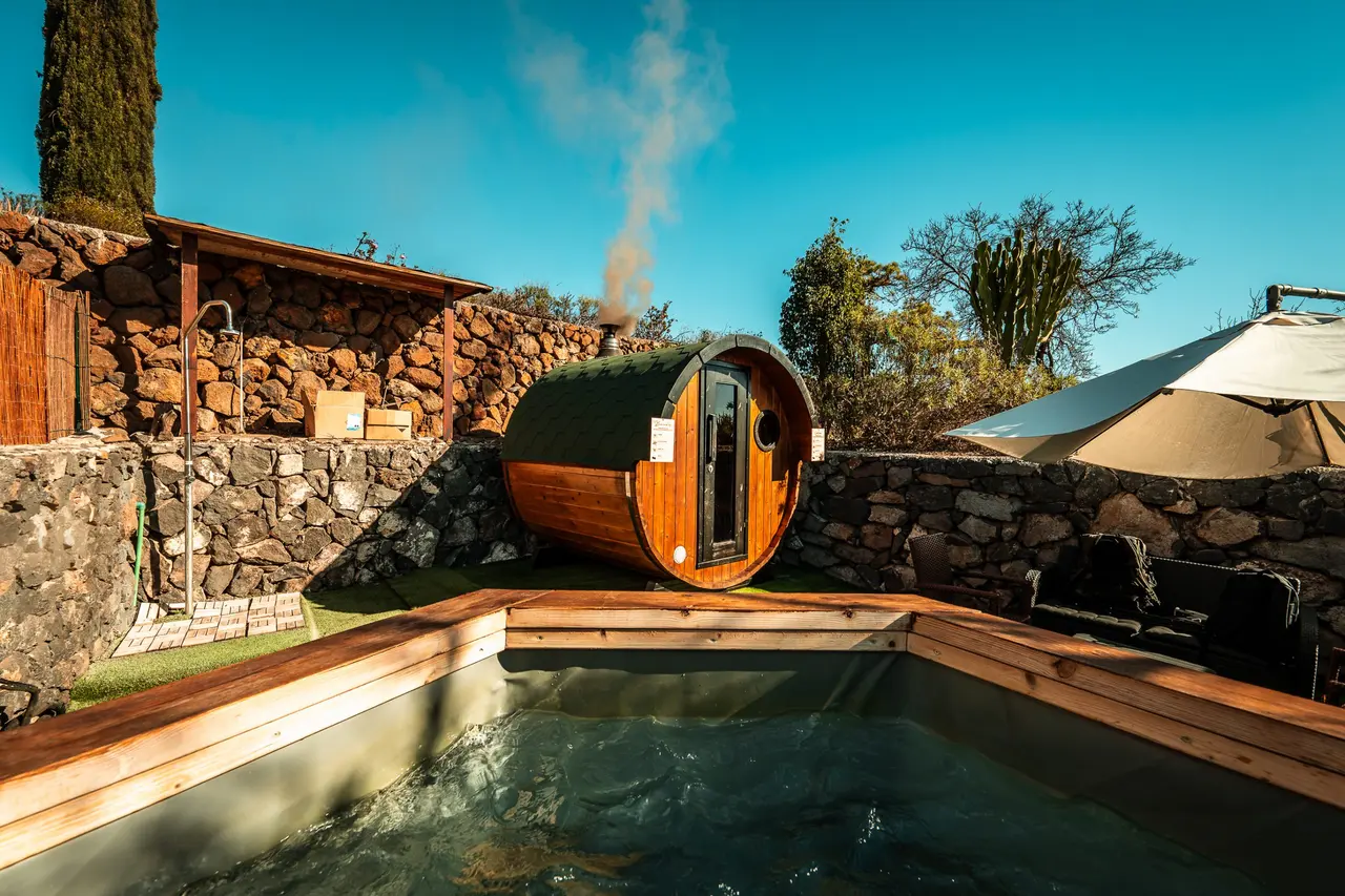 Jacuzzi exterior rectangular con agua en movimiento, rodeado de una plataforma de madera.