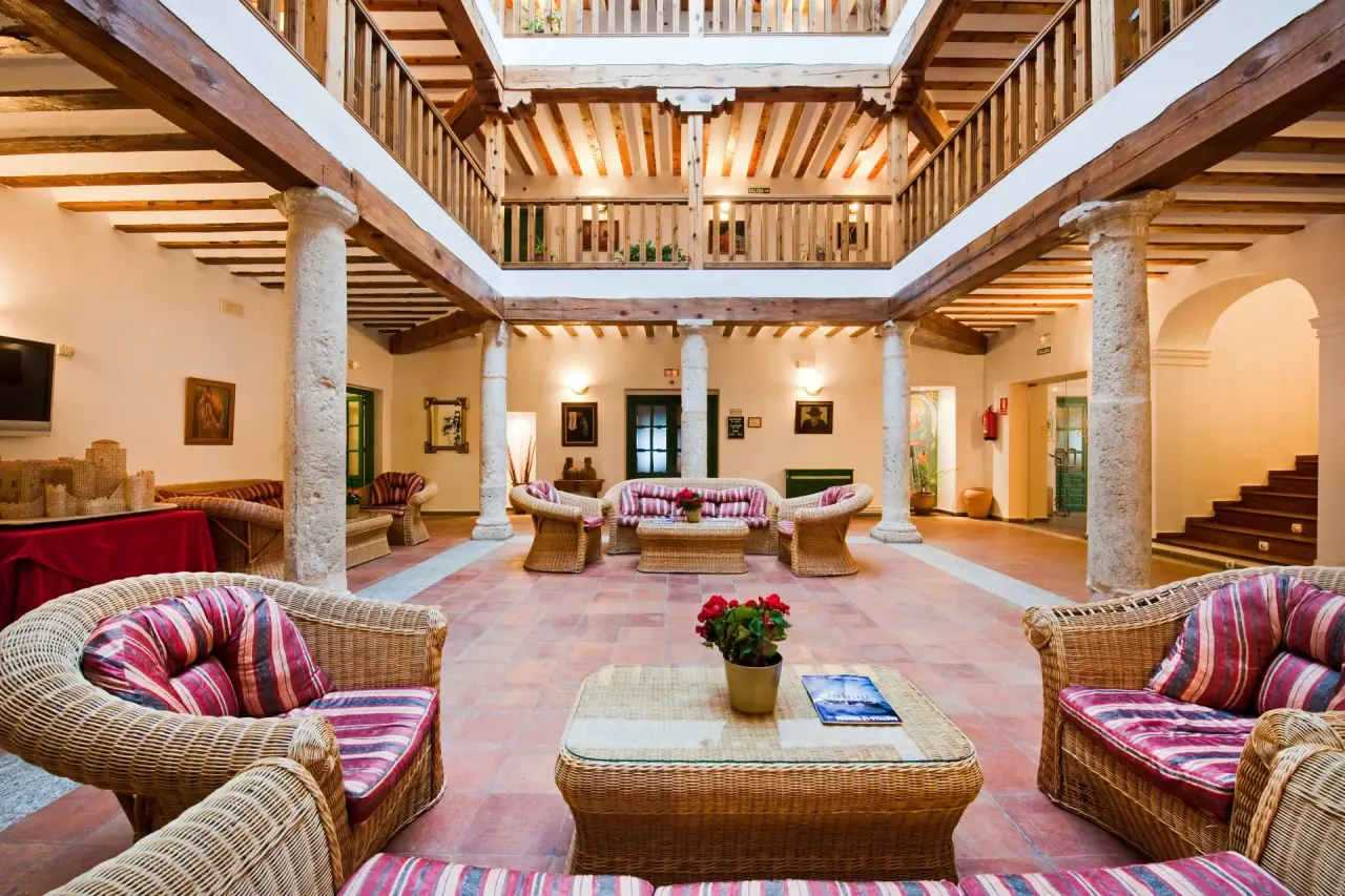 Interior de un patio o salón común en un edificio histórico con arquitectura tradicional, featuring vigas de madera