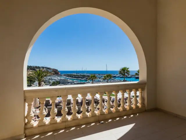 Vista al mar y puerto deportivo desde un arco en la terraza de la suite.