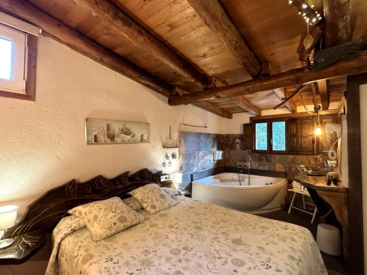 Habitación con cama grande, techo de vigas de madera y bañera de hidromasaje en el interior.