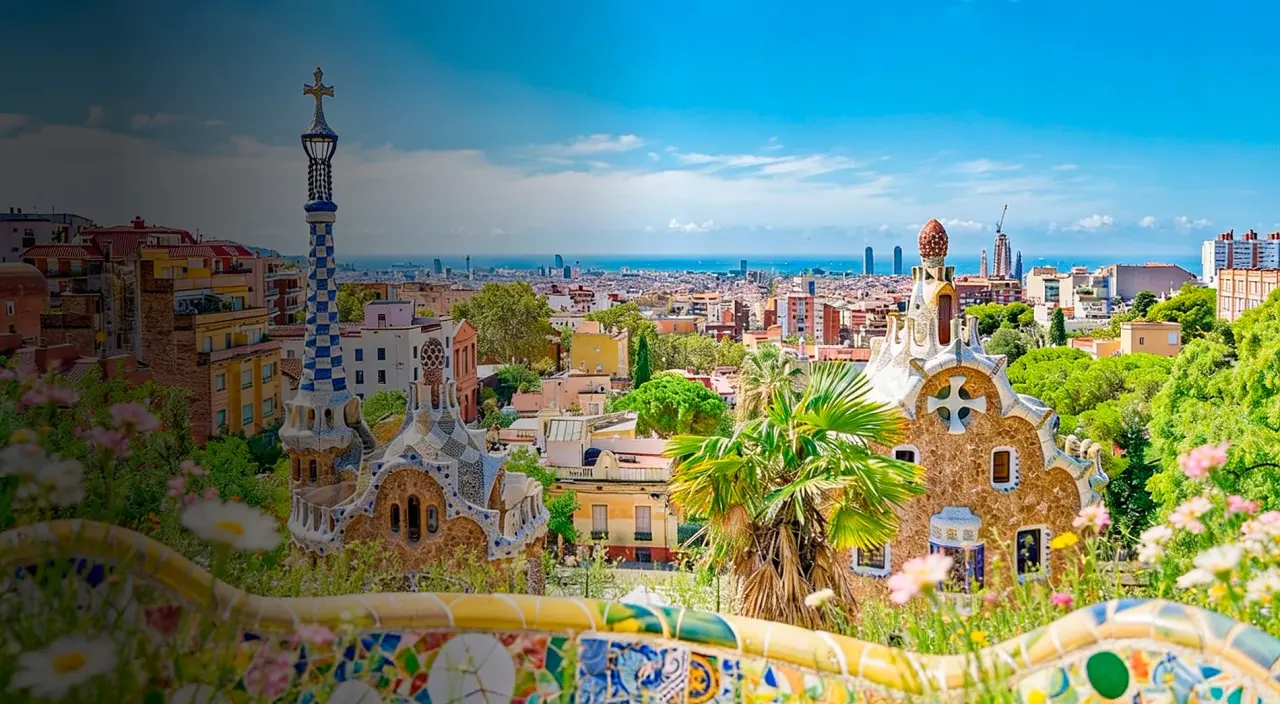 Vista panorámica de Barcelona desde una terraza, con el Parque Güell en primer plano, la Torre de Comunicaciones